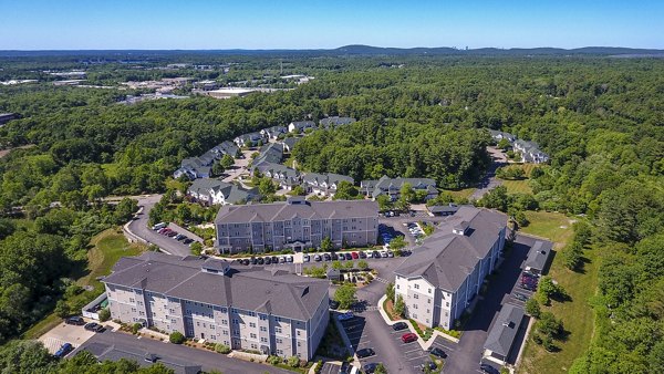 Aerial view of luxury apartments nestled among lush trees and greenery in the community