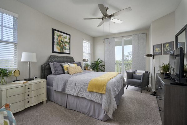 Elegant bedroom featuring modern decor and large windows in Arietta Apartments