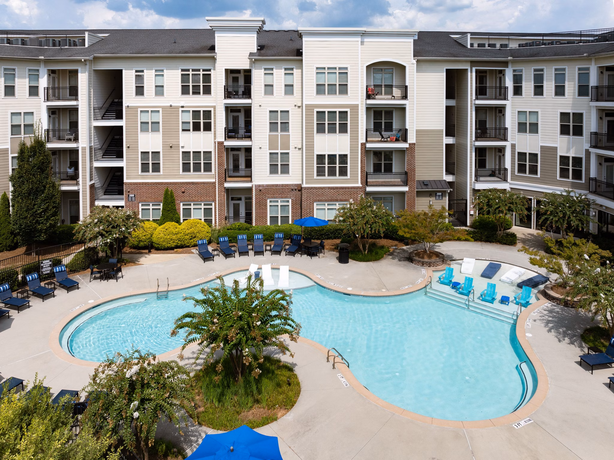 400 Belmont Apartments: Two-story buildings with garages under a clear blue sky in a luxury community
