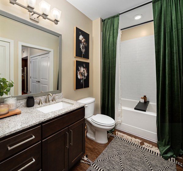Bathroom with wooden floor, modern vanity, and bathtub at 400 Belmont Apartments