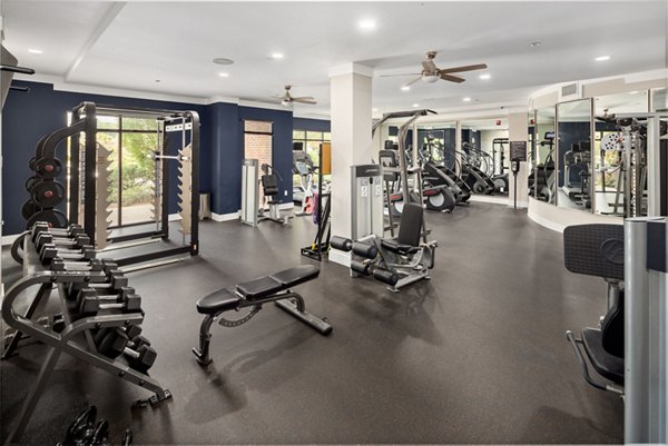 Spacious gym with exercise machines and equipment at 400 Belmont Apartments, offering luxury fitness amenities in a stylish setting