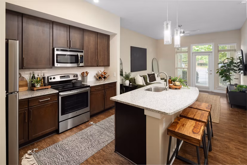 Open-concept kitchen with island and barstools in 400 Belmont Apartments, modern design for luxury living