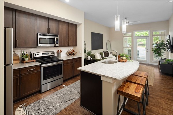 Open-concept kitchen with island and barstools in 400 Belmont Apartments, modern design for luxury living