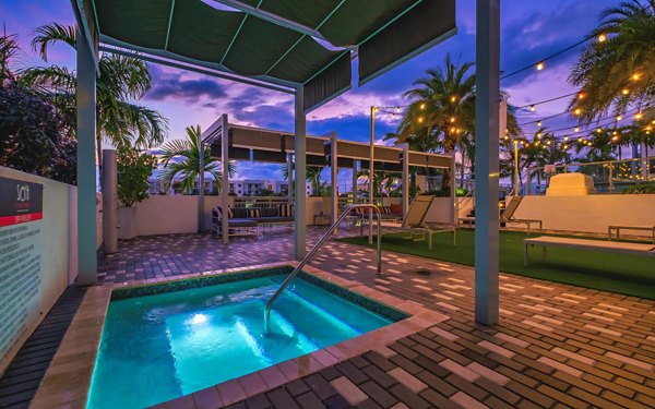 Cozy hot tub area at South of Atlantic Apartments featuring relaxing seating and lush greenery