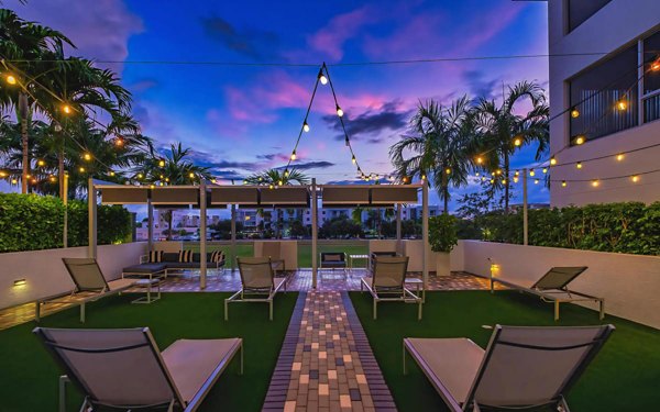 Serene courtyard with lush greenery at South of Atlantic (SofA) Apartments, featuring inviting seating areas and modern design elements