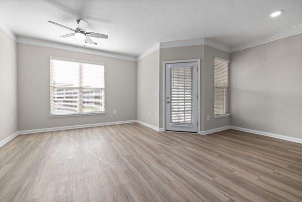 Modern living room with stylish furnishings and large windows at Windsor at Tryon Village Apartments