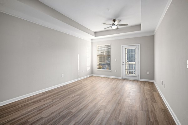 Spacious living room with modern dÃ©cor and large windows at Windsor at Tryon Village Apartments, offering luxury living