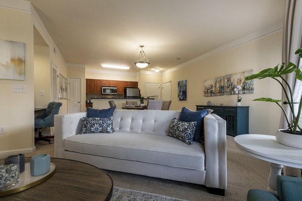 Living room with modern furnishings and large windows at Windsor at Tryon Village Apartments in Cary, showcasing Greystar luxury apartment living