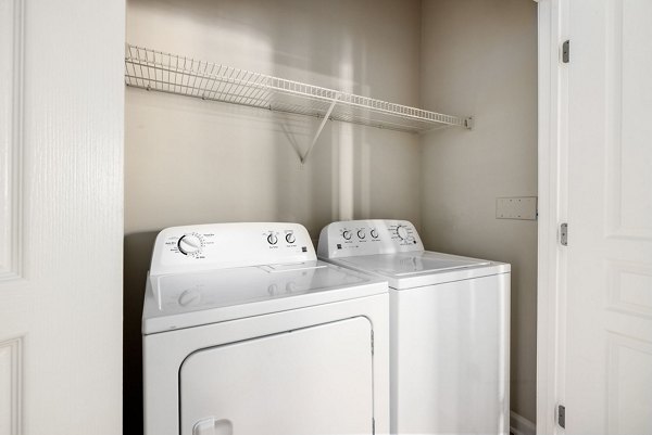 Laundry room with modern appliances at Windsor at Tryon Village Apartments in Cary, showcasing convenient living spaces