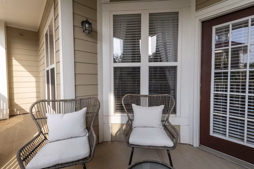 Patio with cozy seating and lush surroundings at Windsor at Tryon Village Apartments