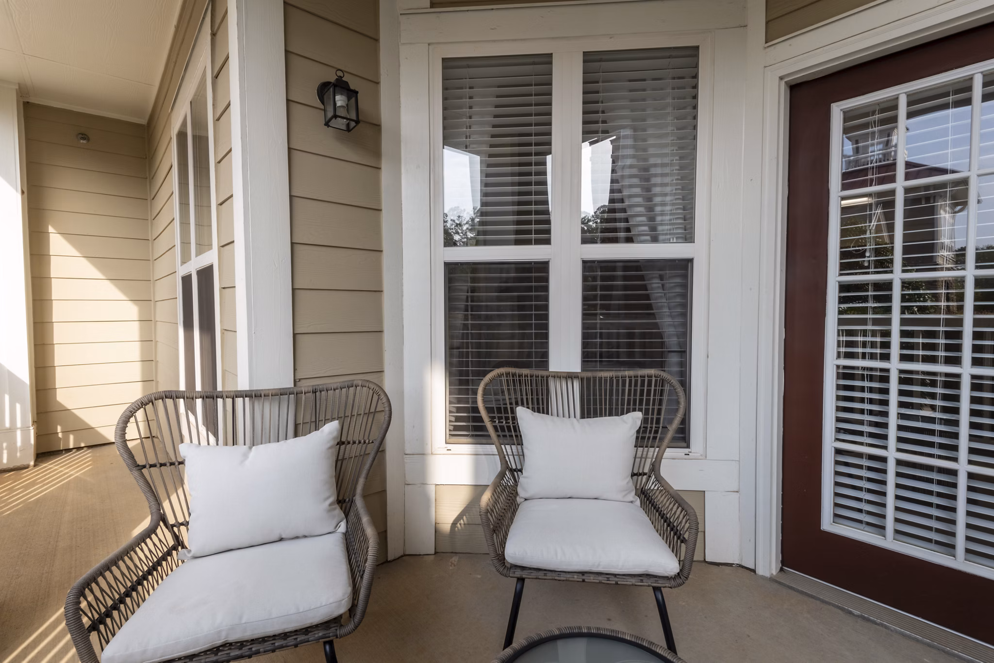Patio with cozy seating and lush surroundings at Windsor at Tryon Village Apartments