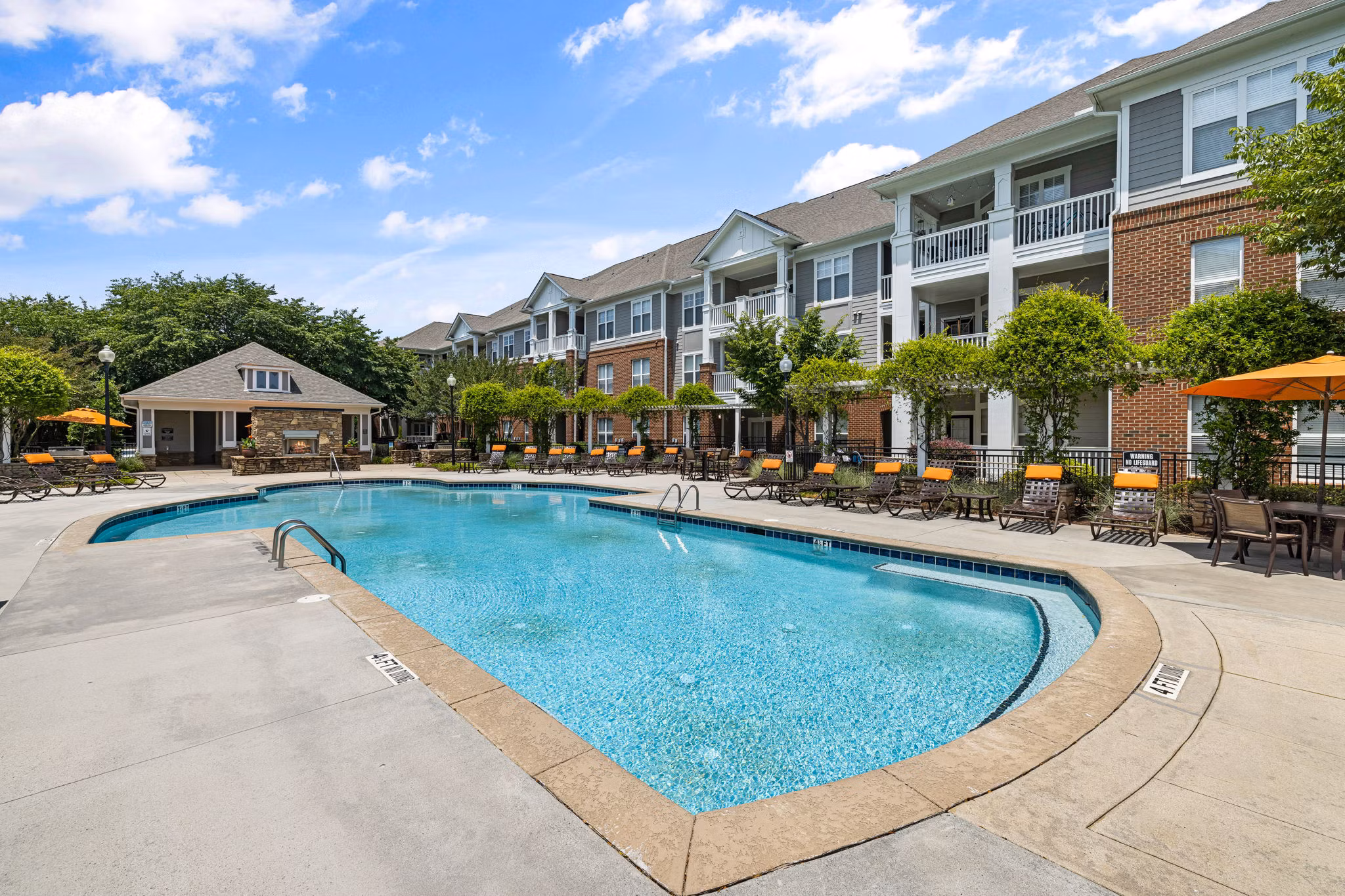 Resort-style pool with lounging areas at Windsor at Tryon Village Apartments offering luxury living in a vibrant community