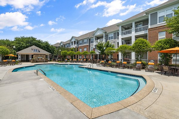 Resort-style pool with lounging areas at Windsor at Tryon Village Apartments offering luxury living in a vibrant community