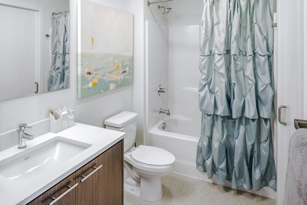 Modern bathroom with sleek fixtures at Dianne Apartments, featuring spacious countertops and bright lighting, ideal for luxury apartment living