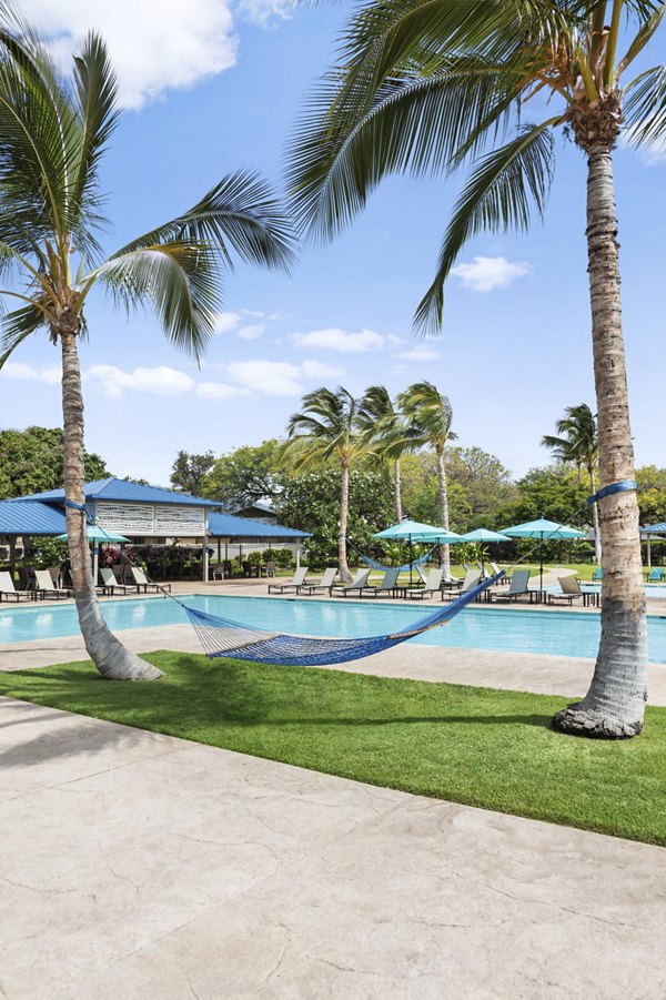 Inviting pool area with loungers at Kalaeloa Rental Homes, perfect for relaxation and leisure activities in a serene setting