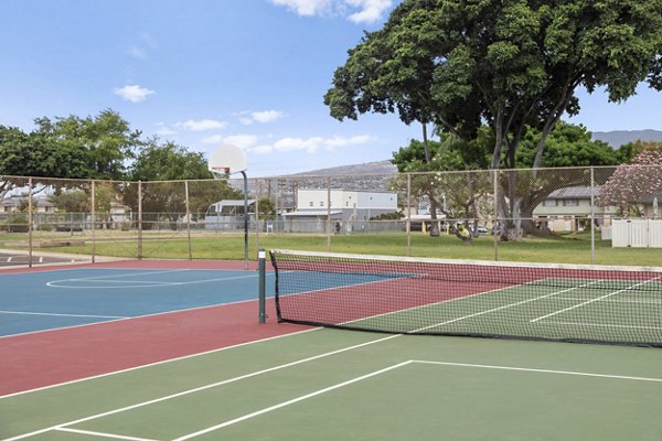 Outdoor sport court at Kalaeloa Rental Homes featuring basketball hoops and tennis lines, ideal for active residents seeking recreational activities
