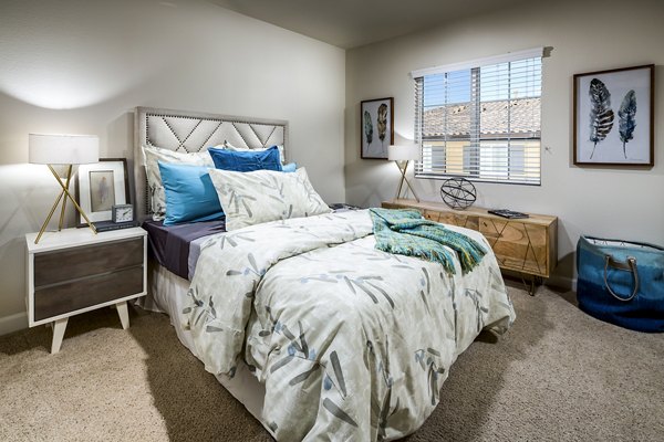 Cozy bedroom featuring elegant decor and ample sunlight at Townhomes at Lost Canyon Apartments