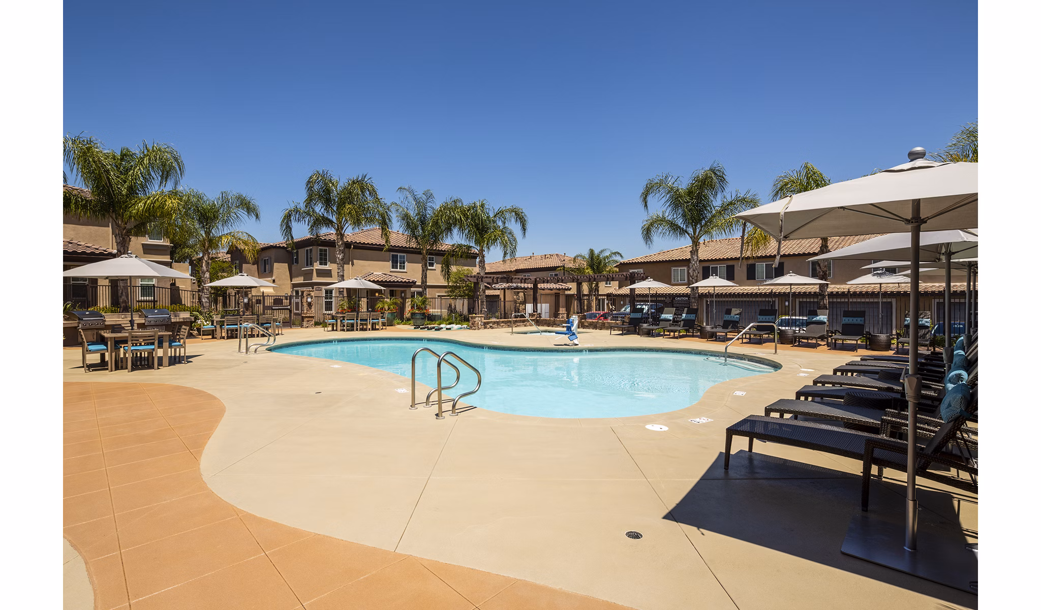 Luxurious pool area at Townhomes at Lost Canyon Apartments offering comfortable loungers and scenic views