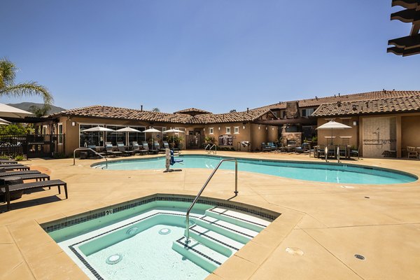 Resort-style pool with lounge chairs at Townhomes at Lost Canyon Apartments, offering a luxurious community feature for residents