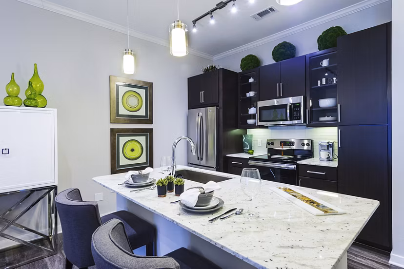 Kitchen featuring modern appliances and marble countertops at Overture Sugar Land luxury apartments