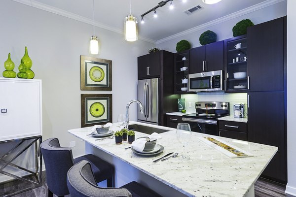 Kitchen featuring modern appliances and marble countertops at Overture Sugar Land luxury apartments