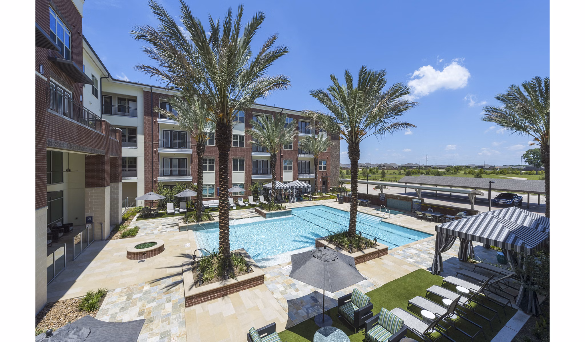 Modern outdoor pool at Overture Sugar Land luxury apartments in Texas, featuring lounge seating and a tranquil garden setting