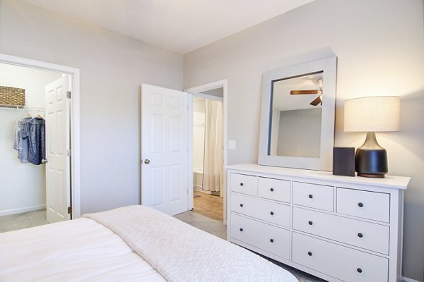 Cozy bedroom with modern decor at Avana North Point Apartments featuring natural light and stylish design