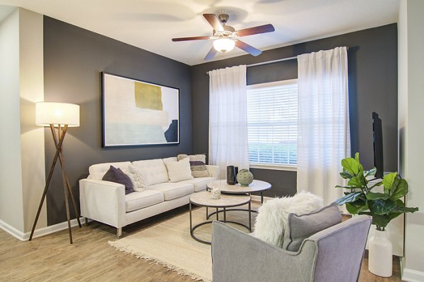 Modern living room with elegant decor at Avana North Point Apartments, featuring plush furnishings and natural light