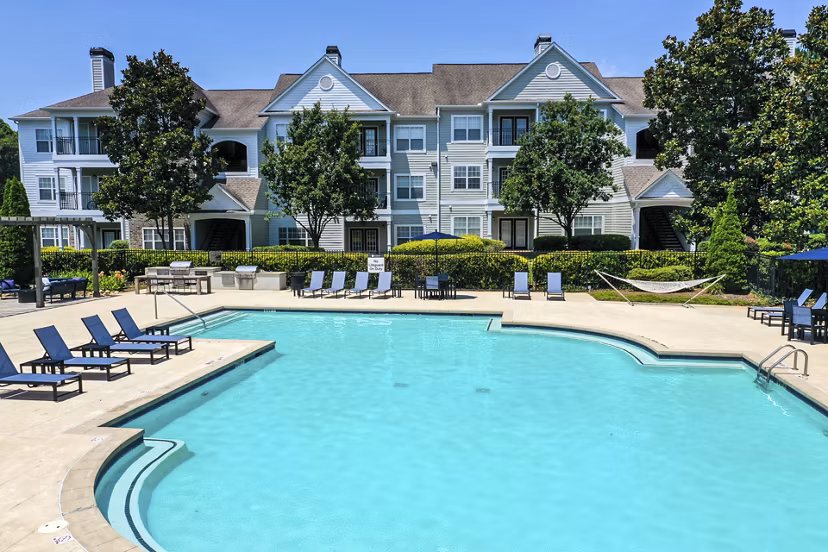 Resort-style pool at Avana North Point Apartments featuring palm trees and lounge chairs