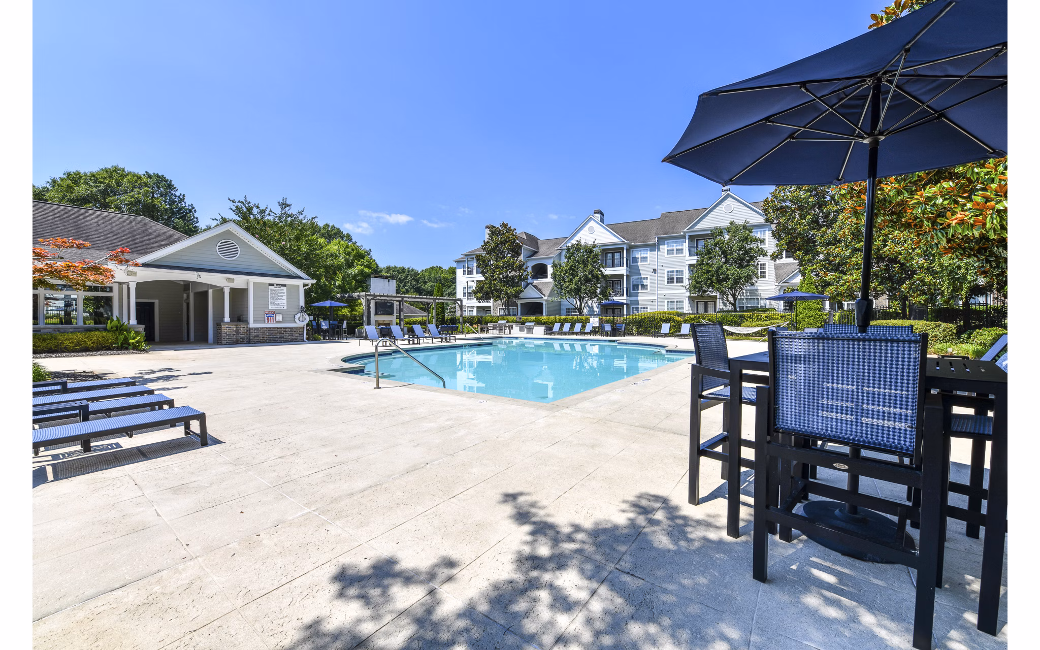 Resort-style pool with lounge chairs at Avana North Point Apartments, a luxury community offering relaxation and leisure