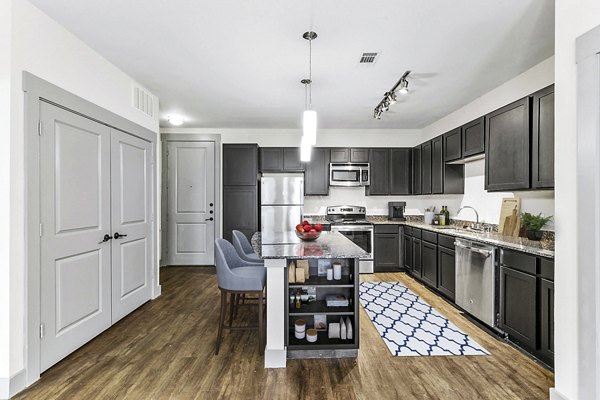 Modern kitchen featuring stainless steel appliances and granite countertops at Landmark on Lovers Apartments
