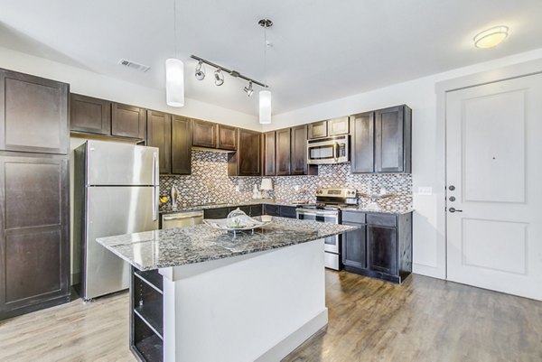 Modern kitchen with stainless steel appliances in Landmark on Lovers Apartments