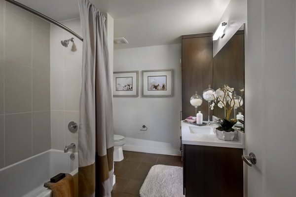 Modern bathroom featuring sleek fixtures and elegant tiling at The Hudson Apartments