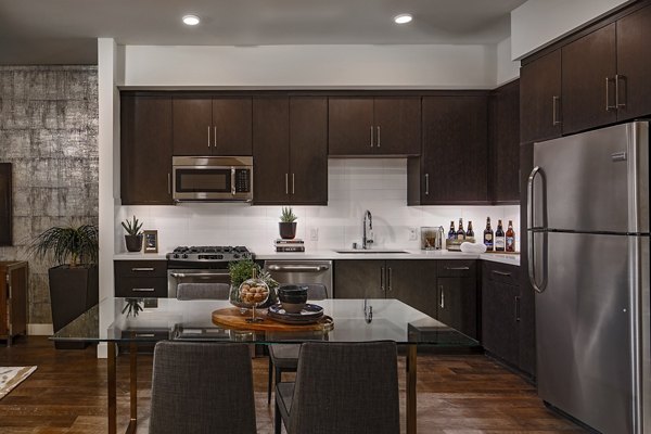 Modern kitchen with stainless steel appliances in The Hudson Apartments