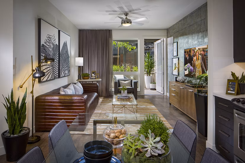 Spacious living room with modern decor and large windows in The Hudson Apartments