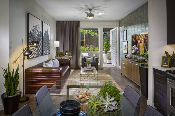 Spacious living room with modern decor and large windows in The Hudson Apartments