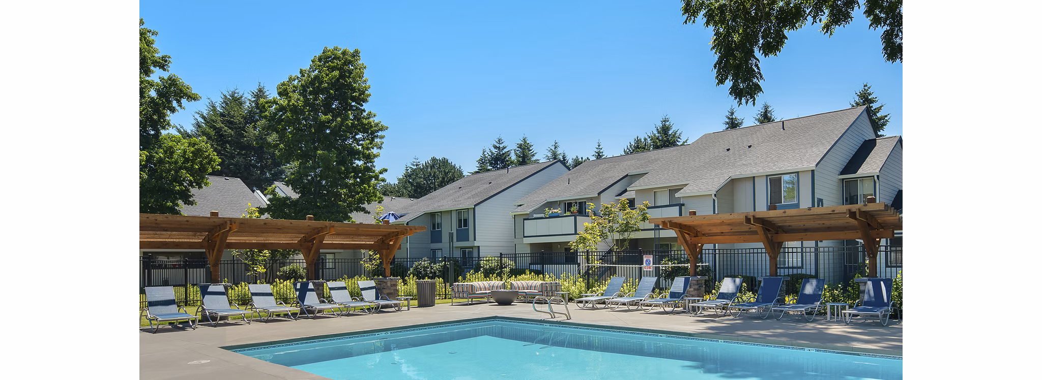 Luxurious pool area with sun loungers at Brookside 112 Apartments, perfect for relaxation and social gatherings in a modern setting