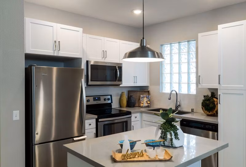 Sleek modern kitchen with island and stainless steel appliances at Amerige Pointe Apartments