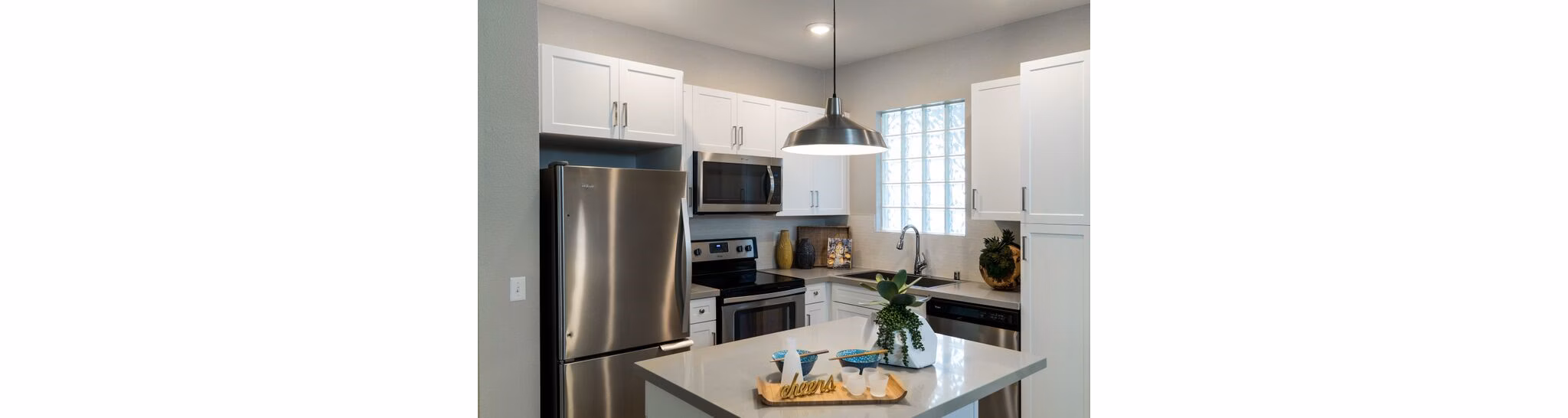 Sleek modern kitchen with island and stainless steel appliances at Amerige Pointe Apartments