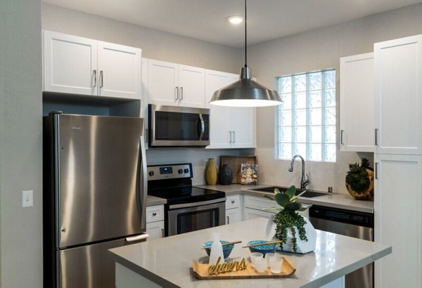 Sleek modern kitchen with island and stainless steel appliances at Amerige Pointe Apartments