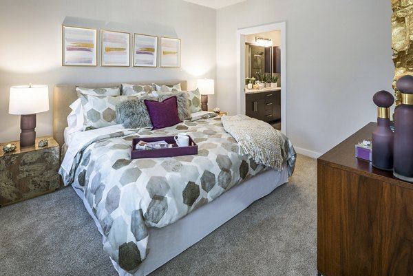 Cozy bedroom featuring a plush bed, stylish nightstands, and elegant artwork on the walls
