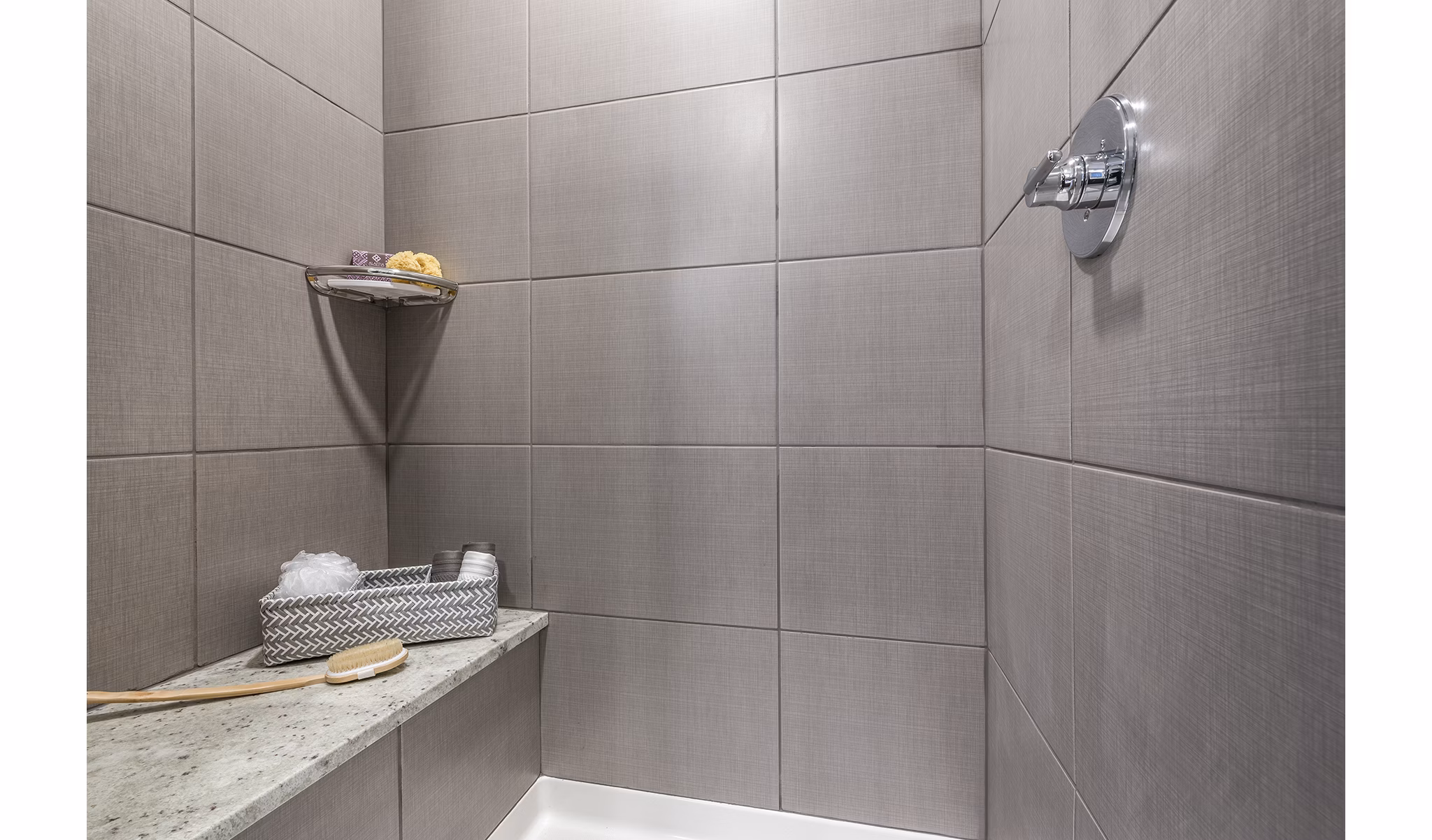 Tiled shower area with built-in shelf for toiletries at luxury apartments
