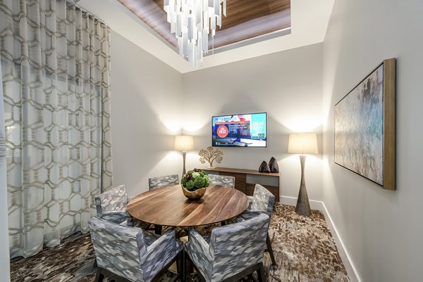 Modern dining room featuring a round wooden table and chandelier in luxury apartment