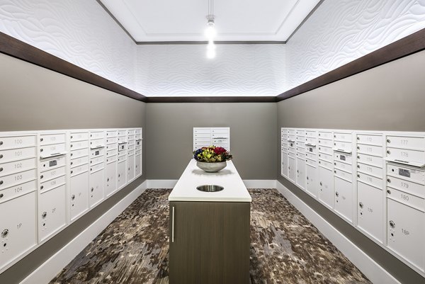 Mailroom with multiple mailboxes and a central table in luxury apartment community