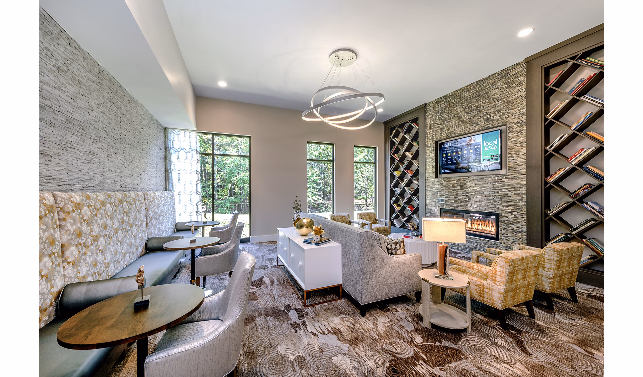 Modern lounge area featuring cozy seating, a fireplace, and bookshelves at luxury apartments