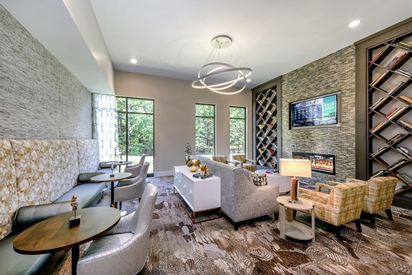 Modern lounge area featuring cozy seating, a fireplace, and bookshelves at luxury apartments