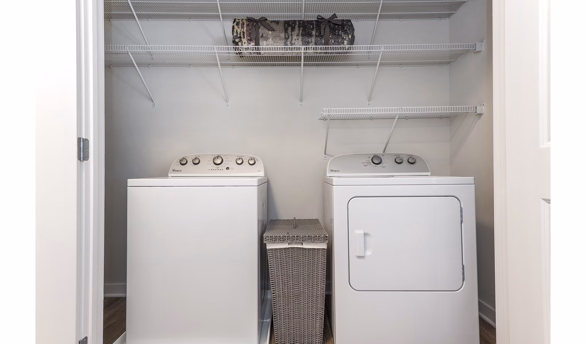 Laundry area featuring a washing machine and dryer with shelves in luxury apartments