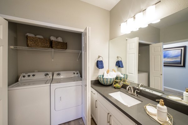 Laundry room featuring modern appliances at Avana One Six Four Apartments