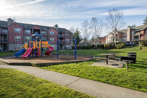Modern playground with colorful slides and climbing structures at Avana One Six Four Apartments, fostering child-friendly community living
