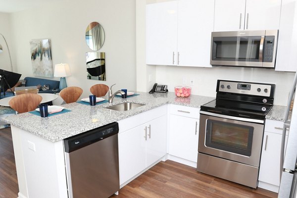 Kitchen featuring modern appliances and sleek countertops at 3 Journal Square Apartments